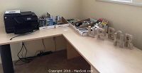 Desk displaying HP OfficeJet Pro 8600 printer, multiple boxes with various items including books, locks, and decorative wooden letters 'WEBR'.