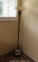Full view of vintage floor lamp showing tall metal stand, marble base, and glass shade.