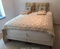 Full view of mattress on boxspring with decorative pillows and shams