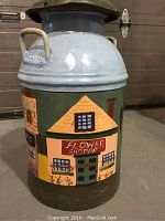 Full view of steel milk can with hand painted Flower Shoppe facade in bright colors.