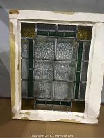 Full view of the leaded stained glass window pane with wood frame, showing the entire geometric design and frame condition.