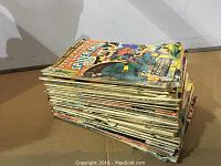 Stack of over 40 vintage Spider-Man comic books showing their spines and cover edges.
