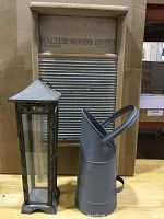 Photo showing the tin and glass candle holder, the gray tin pitcher flower vase, and the wooden washboard with metal ridges in front of a cardboard background.