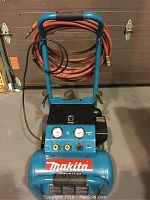 Front view of Makita compressor with coiled hose on handle
