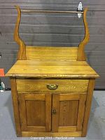 Front view of oak washstand sideboard with harp back and drawer