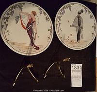 Two Villeroy and Boch collectible fashion plates shown on black background with plates stands