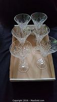 Top view of 6 clear cut crystal Waterford wine goblets arranged in box showing intricate cut patterns on bowls.