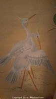 Scroll poster showing two white egrets with detailed feathers standing in water with flowers in background
