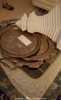 Top view of three silver plated trays stacked inside each other with plaster shelf on top