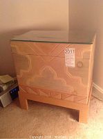 Front angled view showing carved geometric design on wooden box with glass top