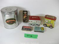 Full photo showing all 6 tins in the lot with visible labels and designs