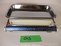 Side angle photo showing the full kitchen scale with cream-colored base and blue scale indicator measuring up to 10 kg, with stainless steel tray on top.