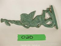 Side view of the metal angel cherub wall mount blowing a trumpet, showing details of the wings, face, and trumpet.