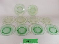Ten Vaseline uranium glass plates arranged in two rows, showing consistent pale green tint with some slight variation due to lighting.