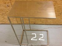 Front view of the rectangular stainless steel table with minor scuffs visible on the work surface.