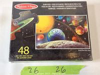 Box showing Melissa & Doug brand, 48 pieces, space scene with planets, and floor puzzle labels in multiple languages.