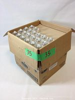 Box containing over 370 votive lamp fuel cells stacked inside, some visible from the top. The box is cardboard and appears to be unopened or mostly unopened.