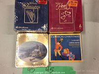 Photo showing four box sets with seal intact: Velvet Classics (4 CDs), Velvet Heart (4 CDs), Handel's Messiah (4 CDs), Classical Christmas (3 CDs). Price stickers visible on two sets.