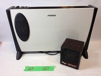 Both heaters shown side by side: a larger Noma panel heater and a smaller Chapin ceramic heater.