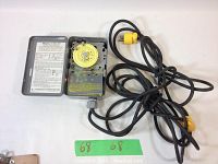 Open view of Intermatic 24 Hour Timer Model T101PZ showing yellow dial with on/off selectors and attached coiled black power cord with yellow plug