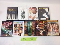 Nine DVDs arranged in rows showing titles and cover art featuring musical artists, movies, and documentaries including Jay Z, Biggie Smalls, Rent, Moulin Rouge, Fame, and Hairspray.