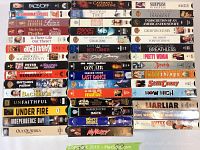 Top view image showing a stack of VHS tapes featuring a wide variety of movie titles from 80's and 90's eras.