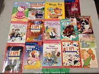 Photo showing all 15 children's books laid out on a flat surface for overview.