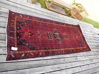 Full view of rug laid flat on deck showing overall design and colors