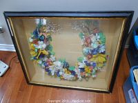 Full front view of the framed Victorian feather wreath showing the colorful feather flowers and leaves inside.