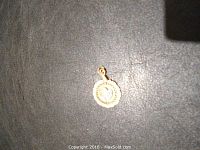 Full view of the Lee pendant showing the circular scalloped base and blue stones on the crescent shape.