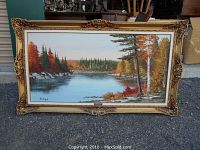 Full view of the framed oil painting showing the autumn lake landscape in Algonquin Park, signed by Bowman on lower left, ornate gold-tone frame present