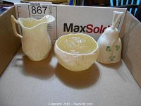 Photo of the three Belleek porcelain pieces including the cream pitcher, sugar bowl, and shamrock bell-shaped piece.