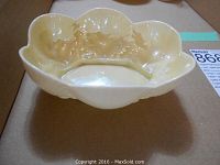 Top and side view of the cream-colored Belleek ceramic dish with scalloped shell design and floral accents.