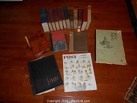 Various older hardcover books including volumes in red, blue, beige bindings plus a scrapbook titled 'Scraps' and a 1952 Evening Post magazine on wooden floor.
