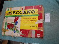 Full top view of the original Meccano box showing significant wear, taped sections, and red, yellow, and green color scheme