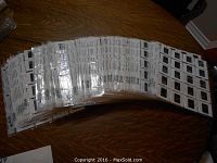 A view of multiple sheets stacked together, each containing twenty trading card slides in clear plastic sleeves.