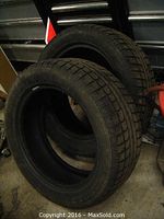 Pair of two snow tires stacked, showing tread and general condition.