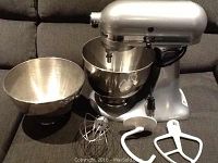 Full kit: mixer, two bowls, and three attachments on sofa