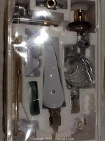 Photo showing all faucet parts packaged in foam, new condition.