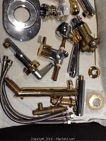 Overview of mixed chrome and gold plated Italian faucet fixtures including valve bodies, spouts, hoses, and escutcheons.