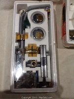 Chrome and gold lavatory faucet with handles securely packaged in foam tray