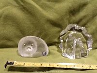 Photo showing the baby seal sculpture beside the pair of penguins sculpture with a measuring tape for scale.