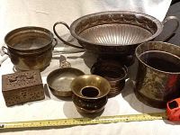 Lot arranged showing all six brass decorative items together with measuring tape for size reference.