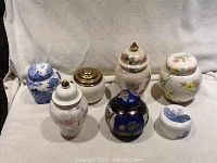 Front view of all seven ginger jars on a soft fabric