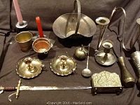 Overview of entire lot showing brass basket, candle holders, small pitcher, ladle, vase, and letter opener.