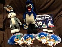 Photo showing the Bugs Bunny plush, Blue Jays bird mascot plush, Canada Day program flyer, Blue Jays pin, and four Blue Jays forest troll dolls.