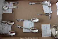 Photo showing six matching salters and various spoons, some marked Sterling and signed Wallace