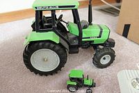 Two Deutz-Allis 6260 tractor models, one large and one small, shown side by side on carpeted floor.