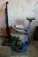 Photo showing Bissell Power Steamer machine with hoses, manual, and cleaning solution bottles placed on carpet.