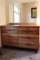 Front view of wooden six drawer dresser showing dovetail drawer fronts and dark wood handles